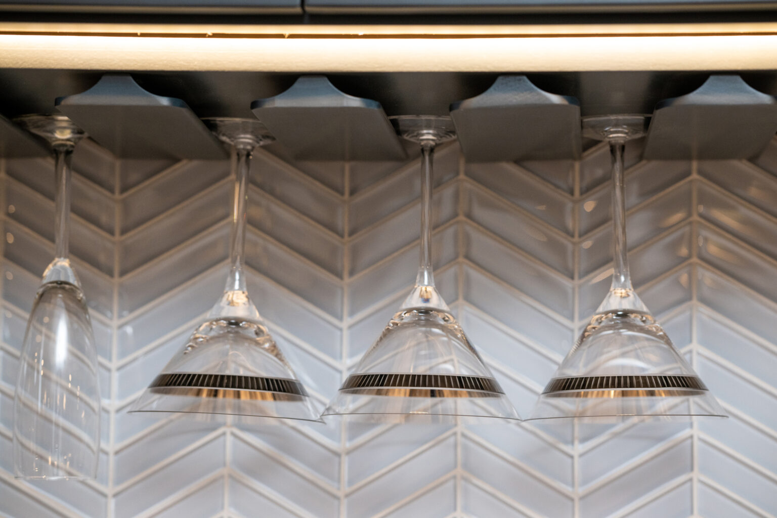 Stemware and tile are the focal point of this wall behind the basement bar in Herndon, VA.