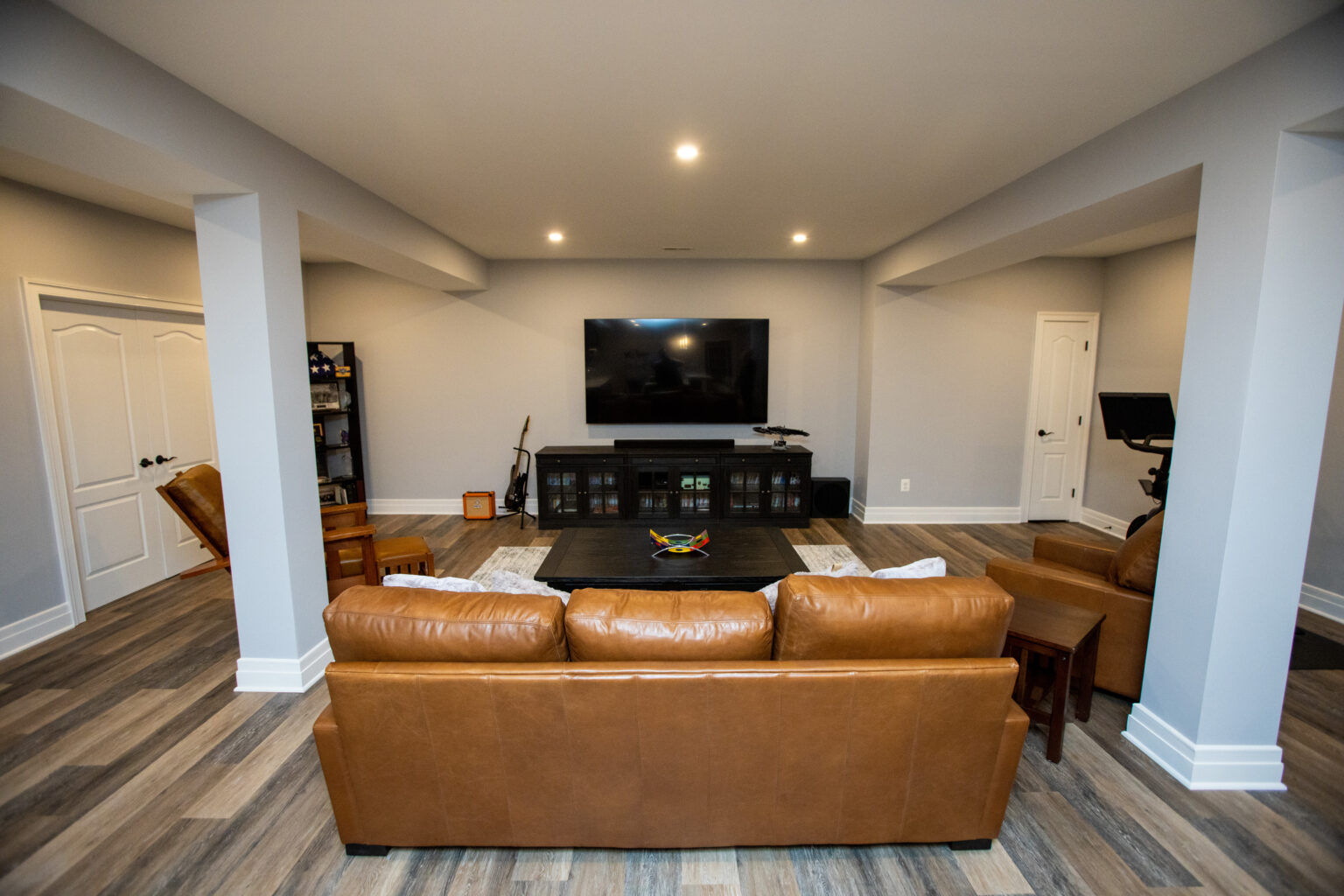 Comfortable couch and chairs to view movies or play video games in this finished basement.