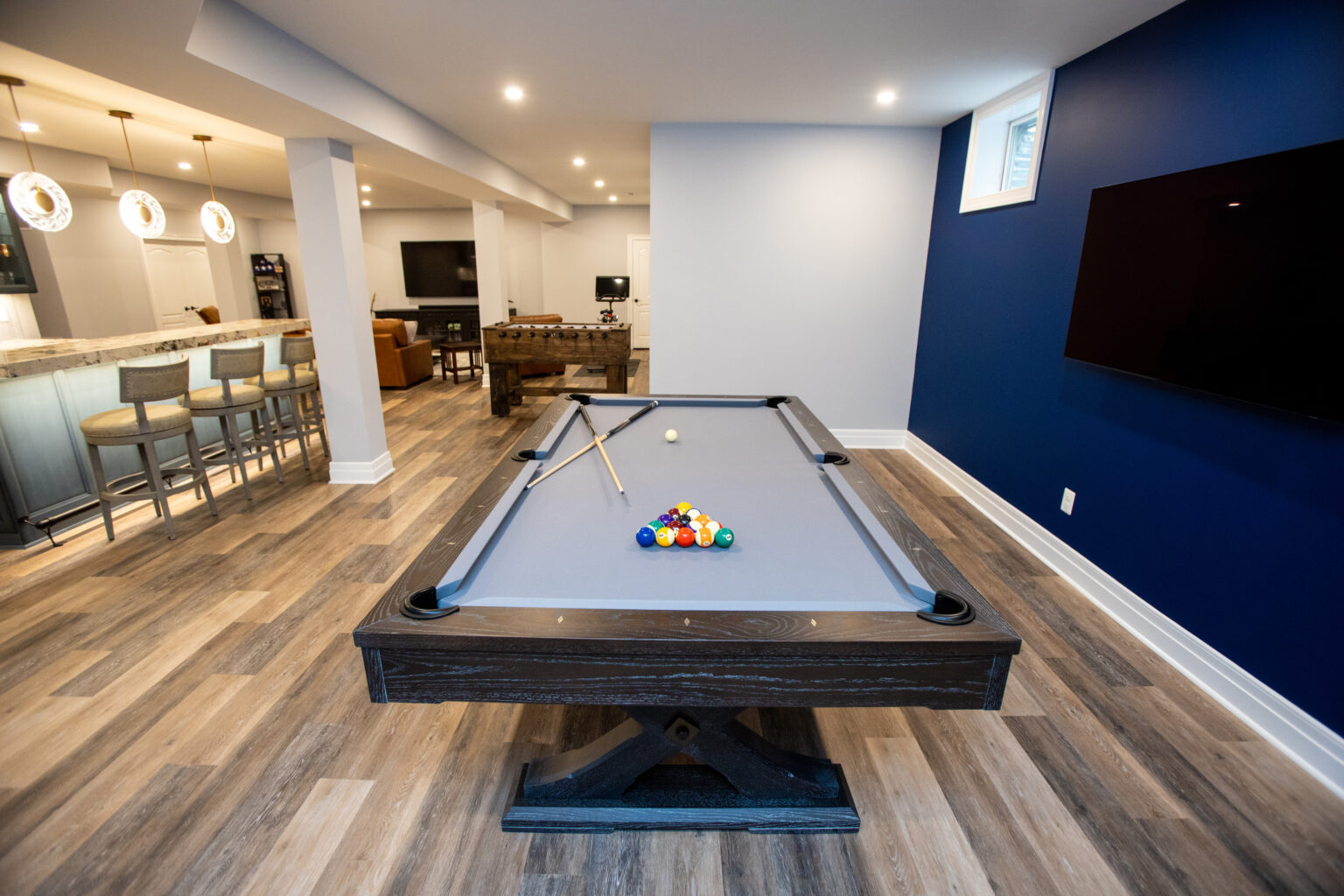 A pool table in a basement with blue walls in Herndon, Virginia.