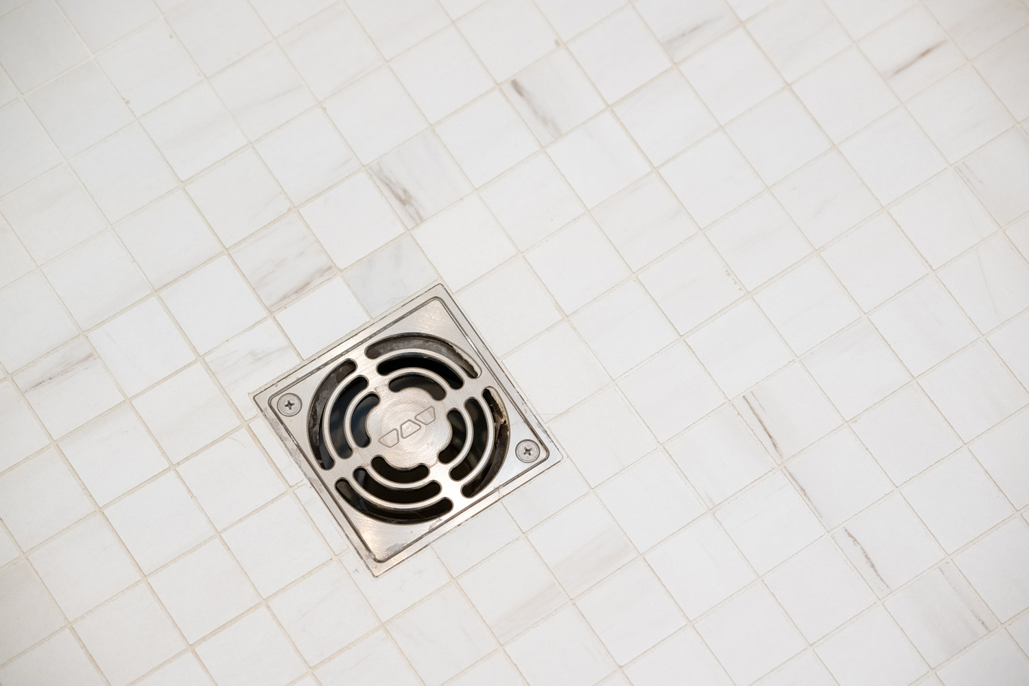 Image by Lesnick Photo Shower drain against a tile shower floor.
