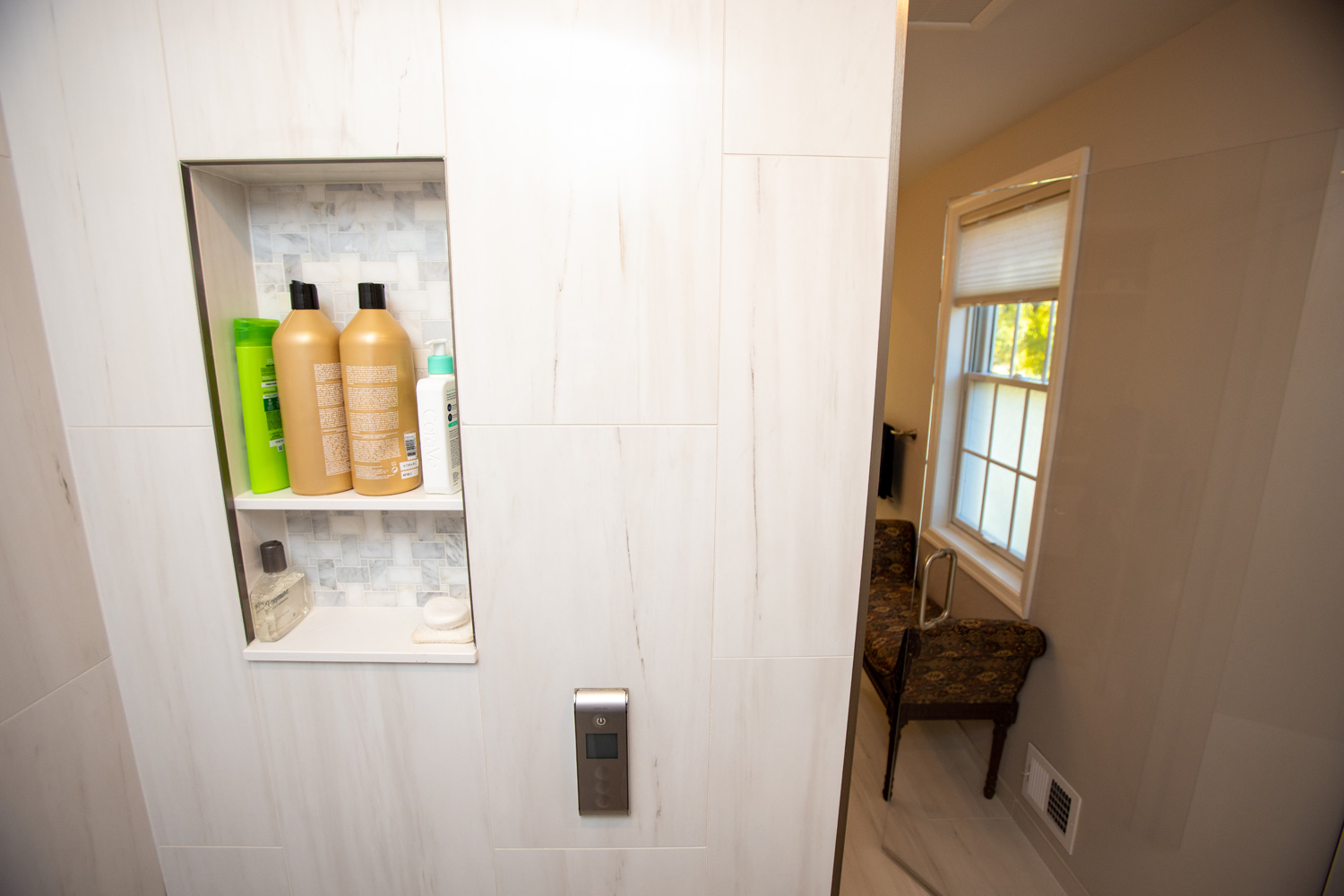 Image by Lesnick Photo A white shower with a built in shelf.