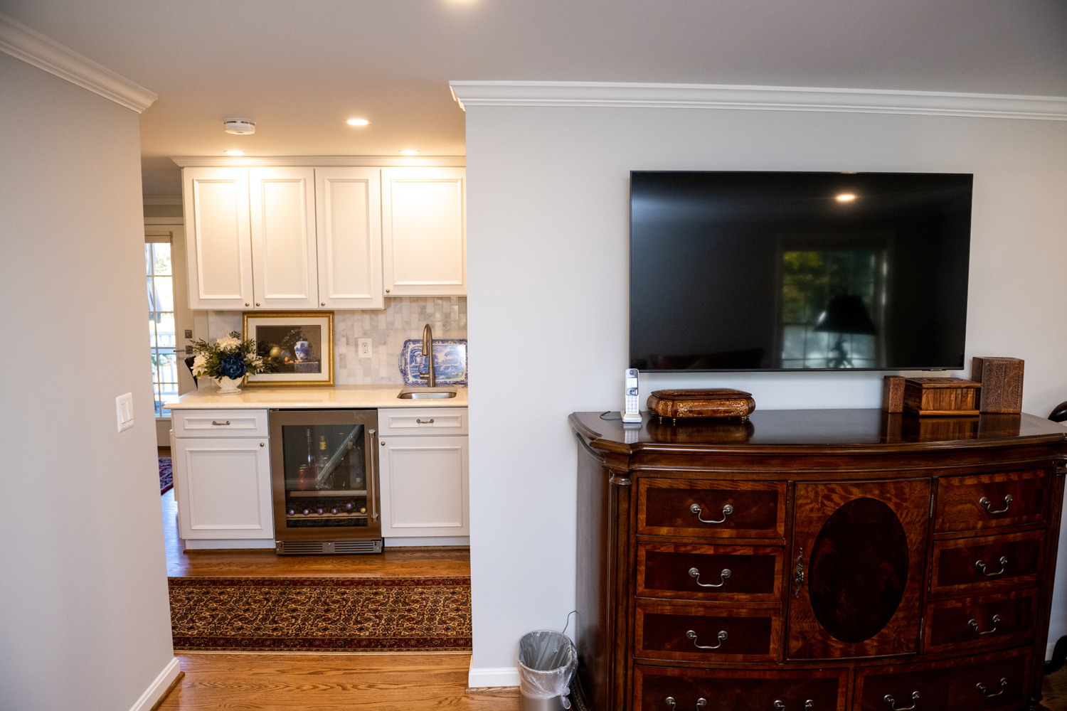 Image by Lesnick Photo A dresser with a TV above it looking towards the master-suite beverage center