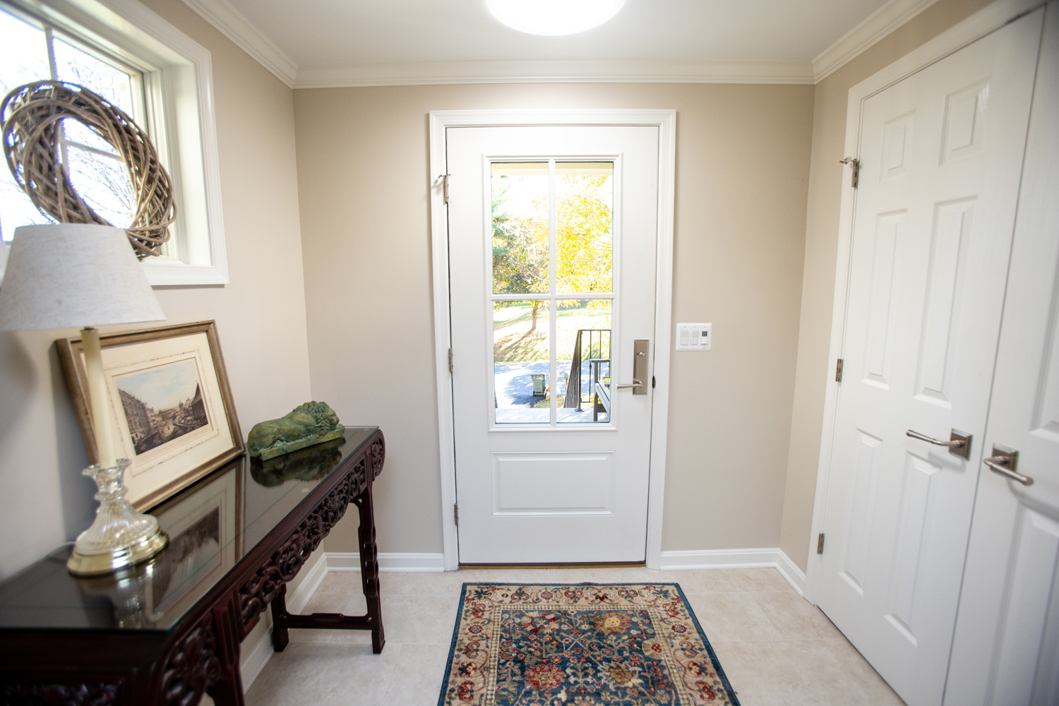 Image by Lesnick Photo A foyer with white door to the outside stoop and a rug.