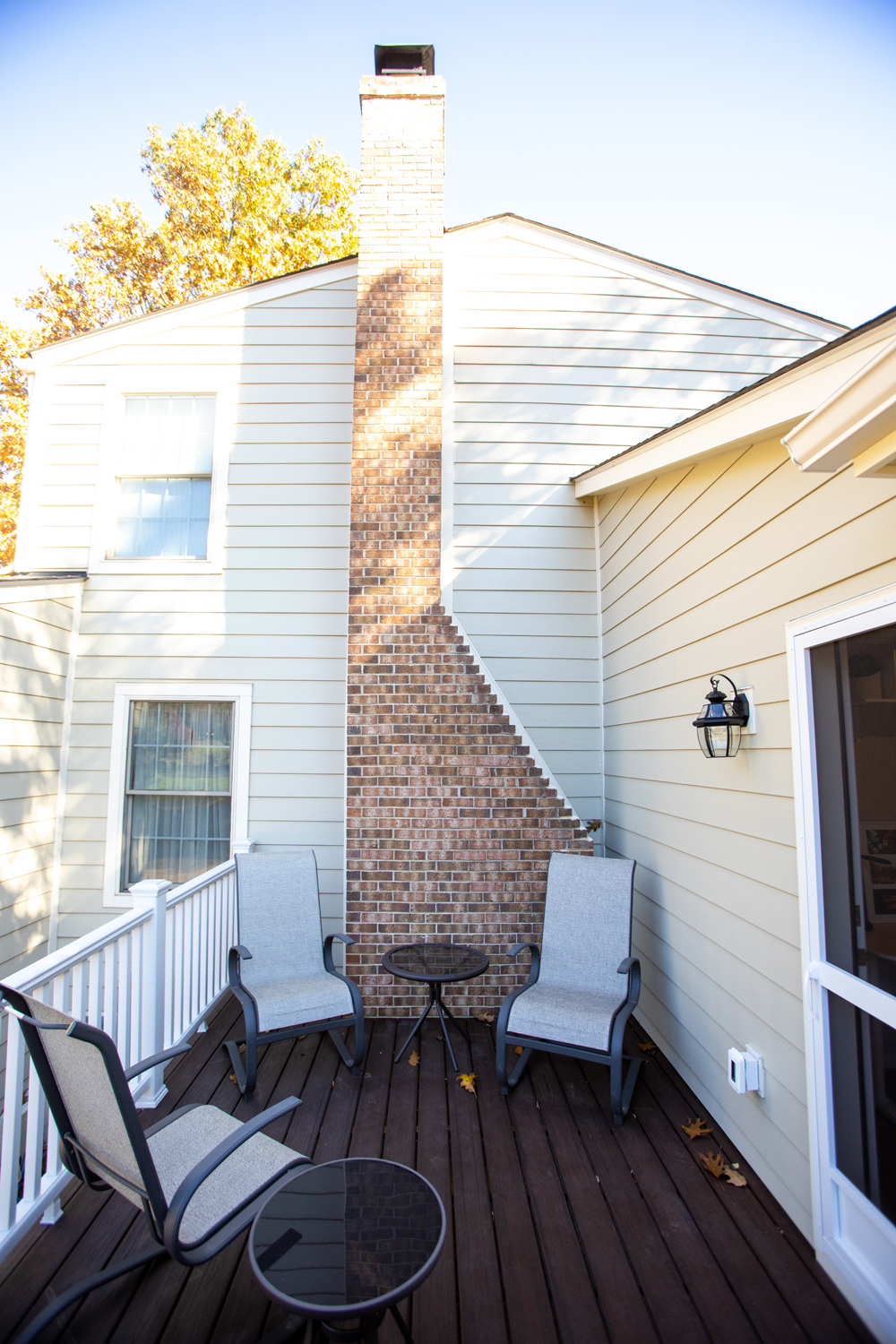 Image by Lesnick Photo Sitting area on this outside deck with brick chimney.