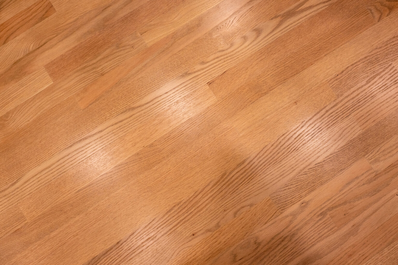 Image by Lesnick Photo Close-up of light brown wooden floor with visible grain patterns and varied shading. The surface is smooth and clean.