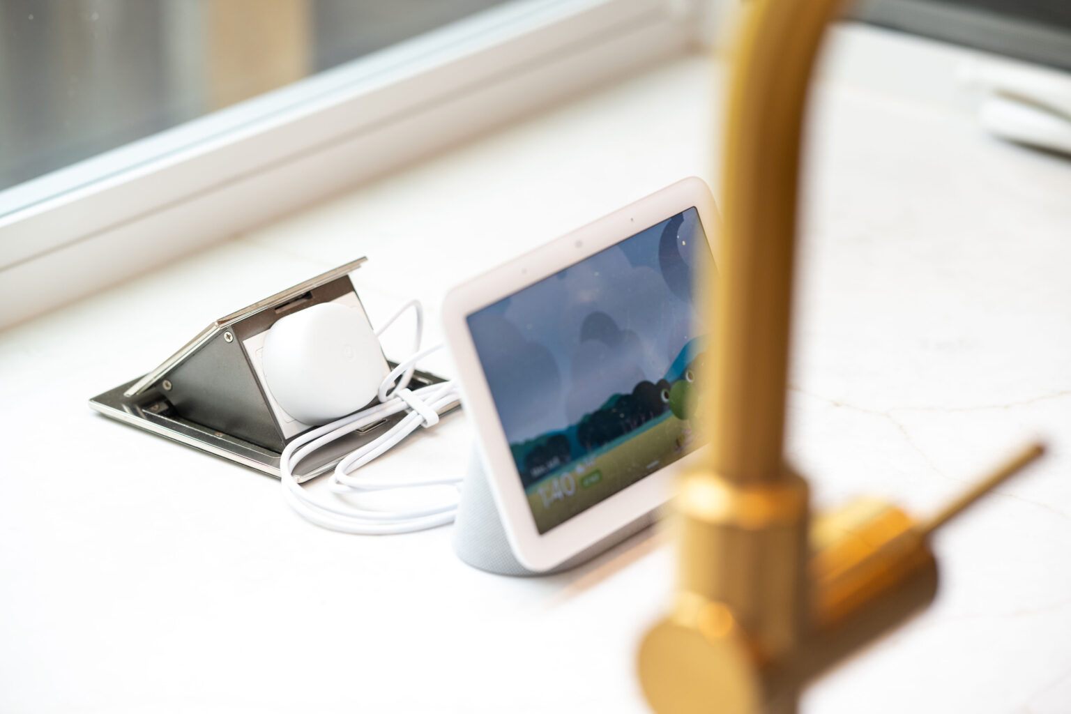 Image by Lesnick Photo A smart display and dock sit on a white countertop near a faucet.