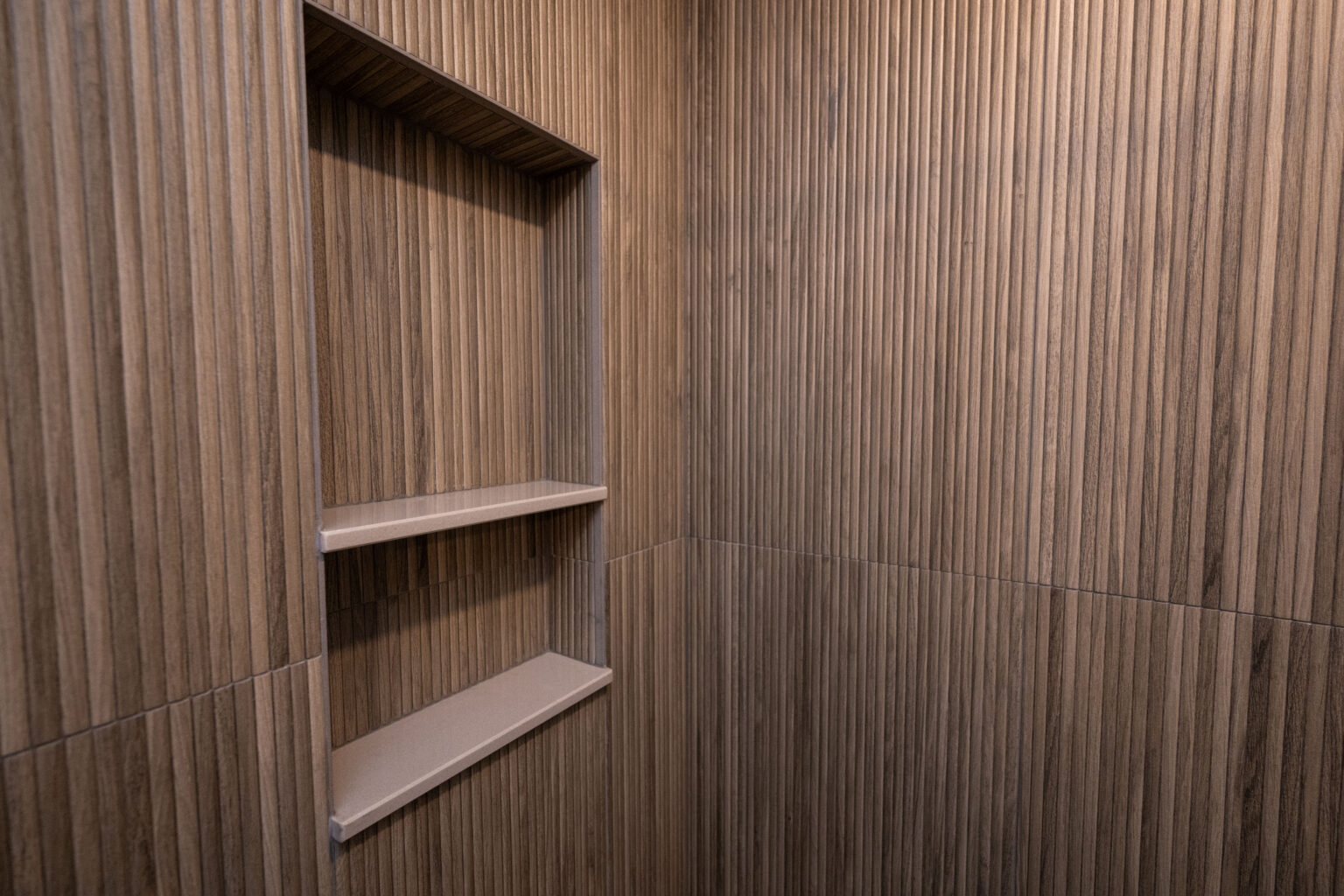 Image by Lesnick Photo A corner with wood-textured walls features a recessed shelf unit with two shelves.